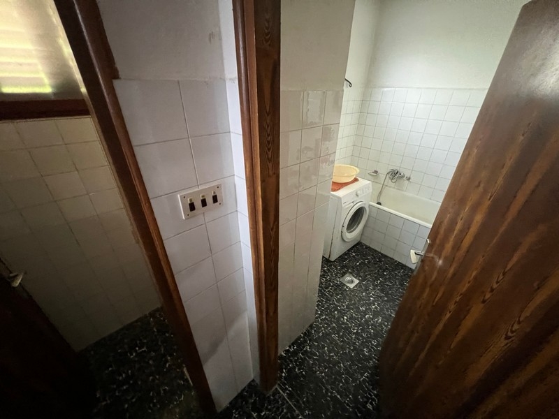Salle de bains simple avec lave-linge et toilettes, montre l'équipement d'un bien sur l'île de Krk.