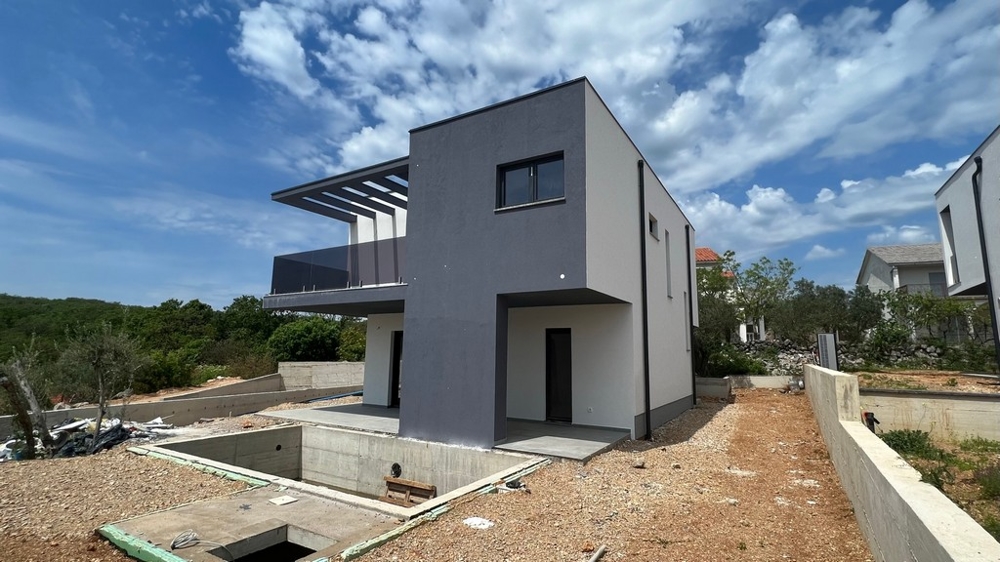 Biens immobiliers Croatie, ville de Krk, villa à vendre île de Krk - vue latérale d'une villa moderne avec fondation en béton et paysage environnant