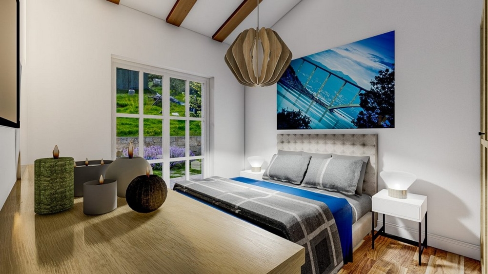 Chambre avec un grand lit double, une couverture rayée bleue et grise, un mur blanc, un tableau et une vue sur le jardin par de grandes fenêtres.