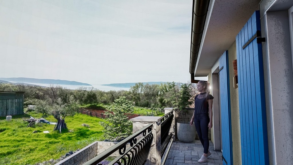 Femme profitant de la vue mer depuis un balcon d'une villa méditerranéenne sur l'île de Krk