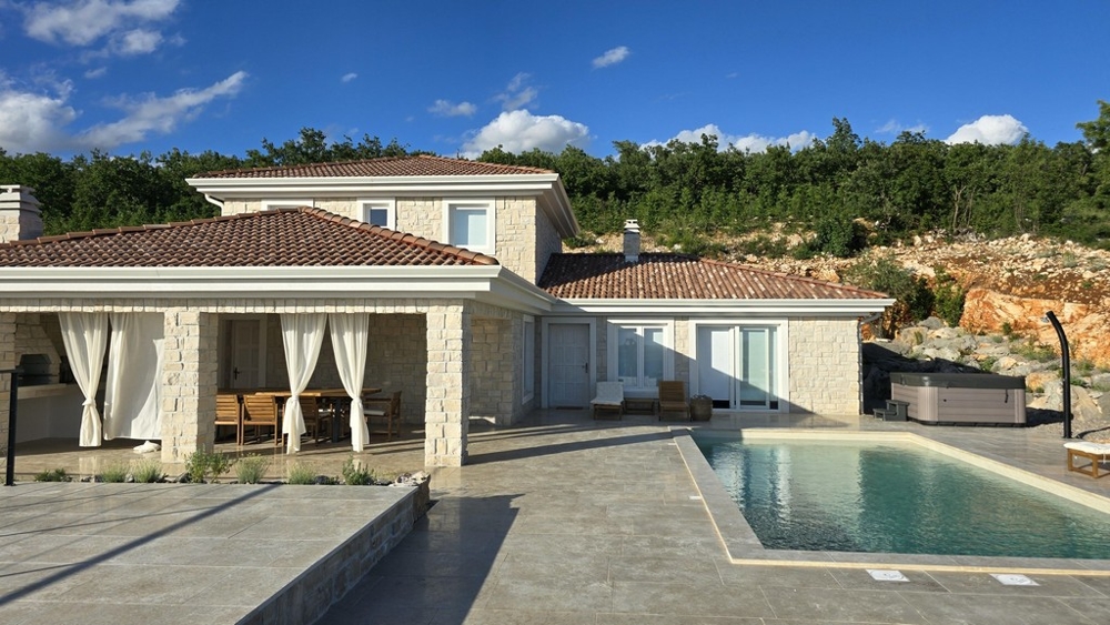 Maison en pierre avec rideaux à la loggia et piscine devant