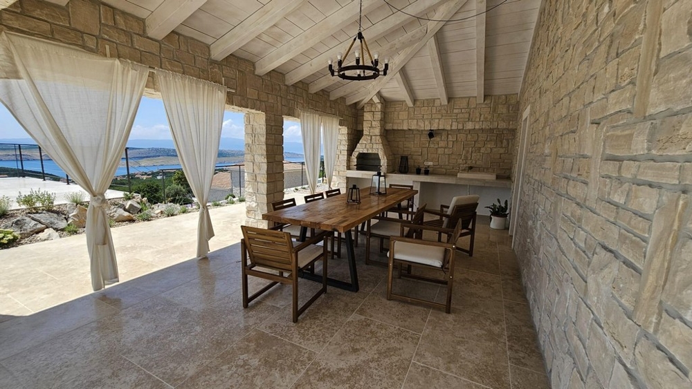 Terrasse avec barbecue et vue mer.