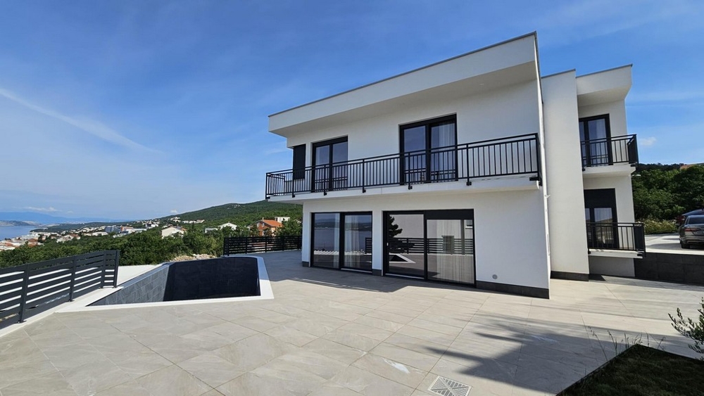 Maison blanche avec grilles de balcon noires et bassins de piscine