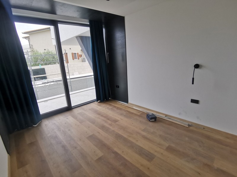 Pièce avec parquet et porte vitrée donnant sur le balcon