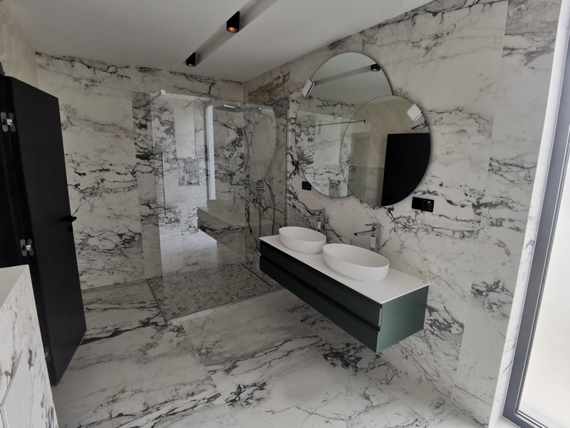 Salle de bains moderne avec éléments en marbre haut de gamme et double vasque