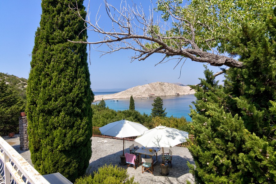 Parasols dans le jardin avec vue entre les cyprès sur la baie