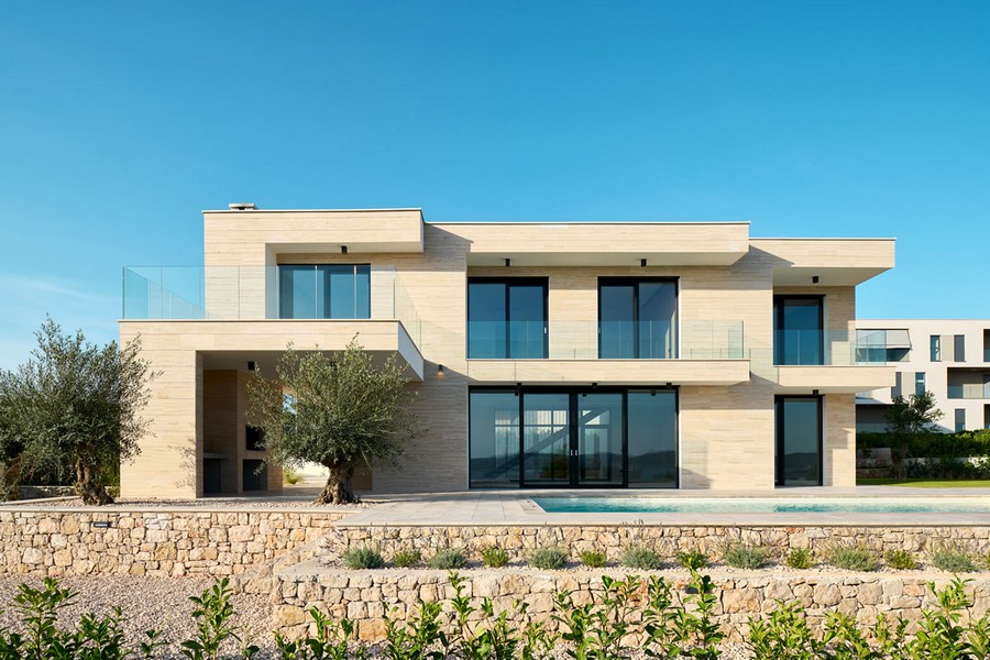 Villa avec façade en pierre claire et olivier près de la piscine