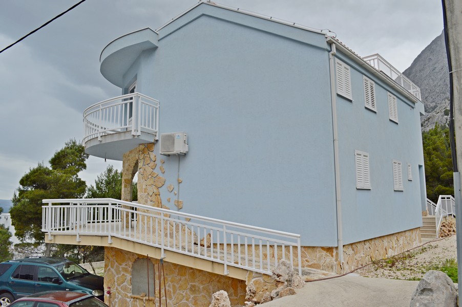 Maison bleue avec mur en pierre et balcon