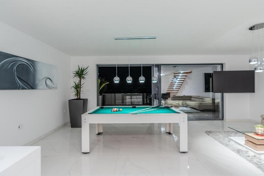 Salle de loisirs avec table de billard et luminaires élégants