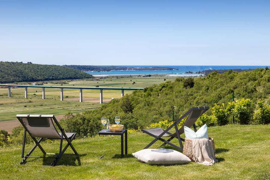 Chaises longues sur la pelouse avec vue sur la vallée jusqu'à la mer