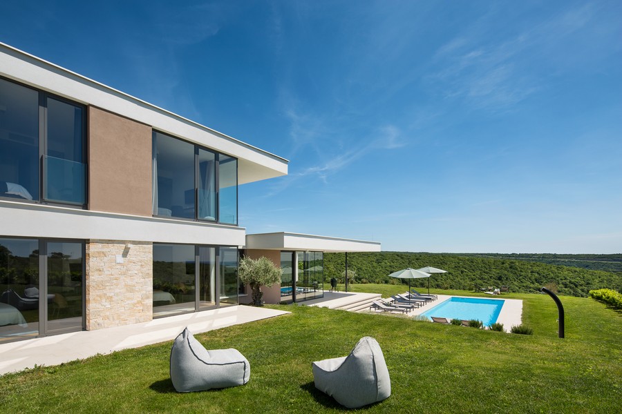 Villa avec pelouse et piscine dans un paysage ouvert