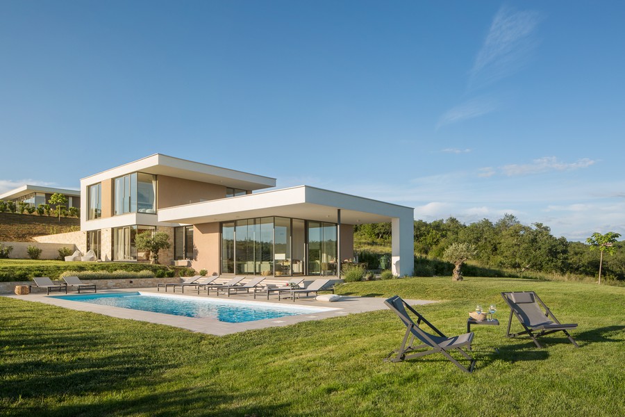 Villa avec piscine et chaises longues sur la vaste pelouse