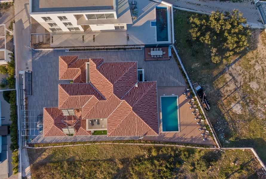 Vue aérienne de la villa H3042, montrant sa toiture et l'espace piscine attenant