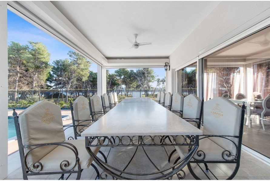 Coin repas couvert de la villa H3042 avec une grande table et des chaises élégantes