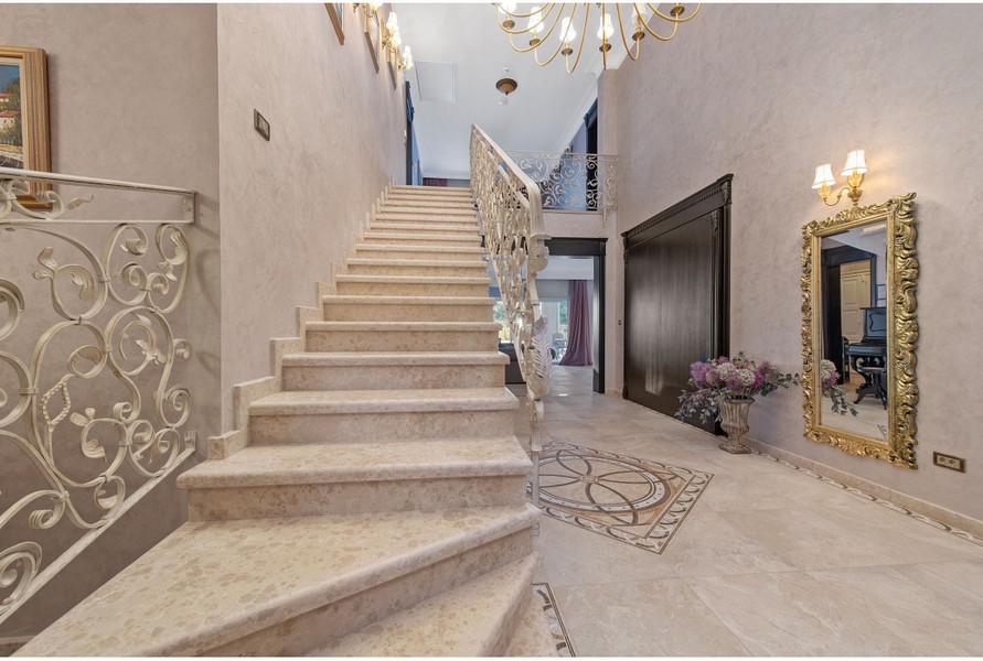 Spacieux hall de la villa H3042 avec un escalier travaillé et des ornements élégants