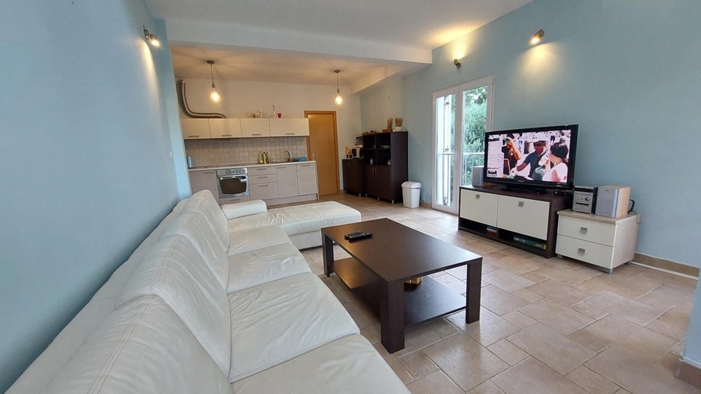 Séjour avec canapé blanc, table basse et télévision dans une maison en Croatie