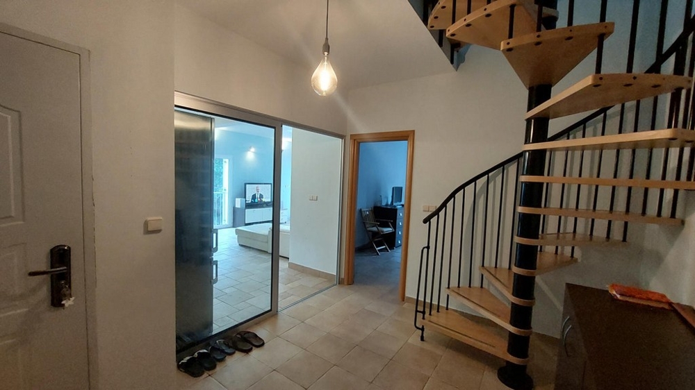 Entrée avec escalier en colimaçon et vue sur le salon dans une maison en Croatie