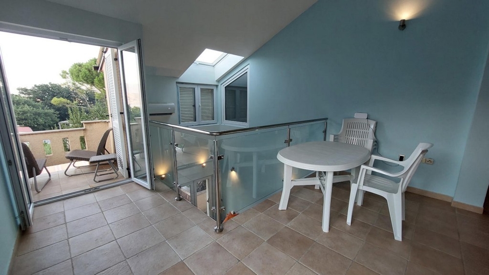 Mezzanine avec table et chaises menant à un balcon dans une maison en Croatie