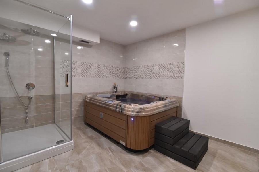 Salle de bains avec douche et jacuzzi, proposée par l'agence immobilière Panorama Scouting