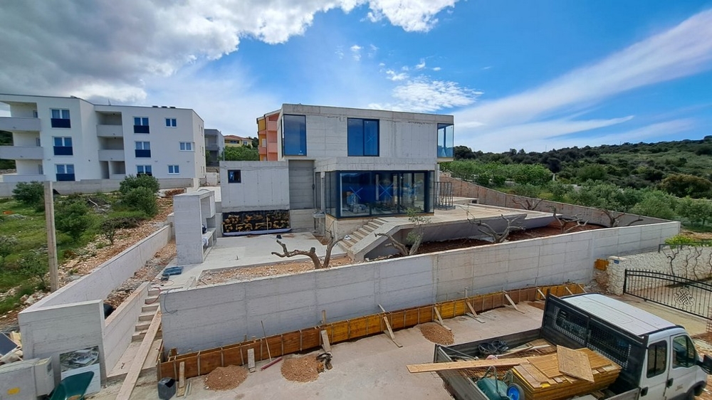 Gros œuvre avec fenêtres bleues derrière le mur en béton
