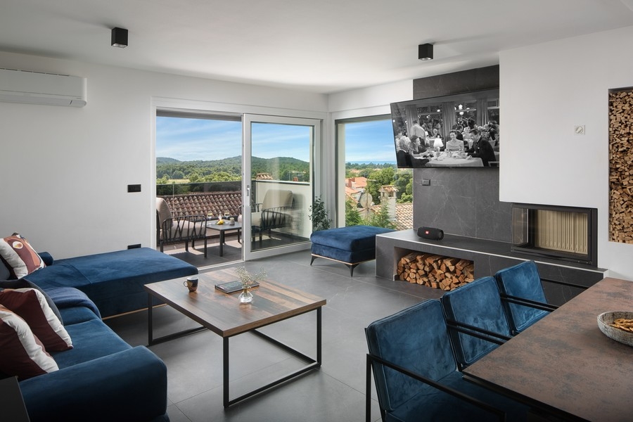Salon moderne avec cheminée haut de gamme et vue sur la mer.