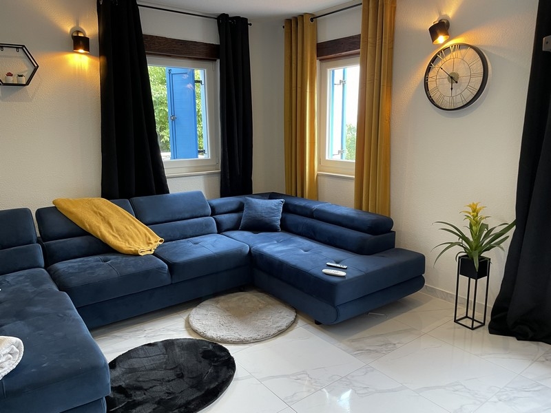 Canapé bleu haut de gamme et beaux sols carrelés dans le salon.