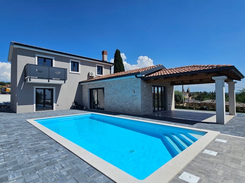 Maison avec mur en pierre naturelle et pergola à côté de la piscine