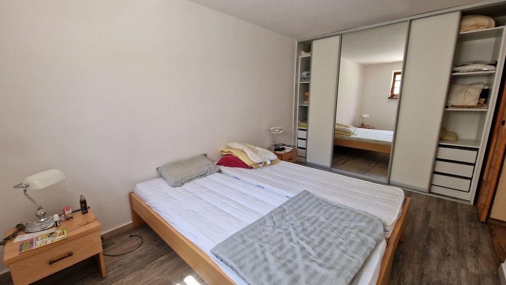 Chambre avec lit double, grande armoire et aménagement minimaliste.