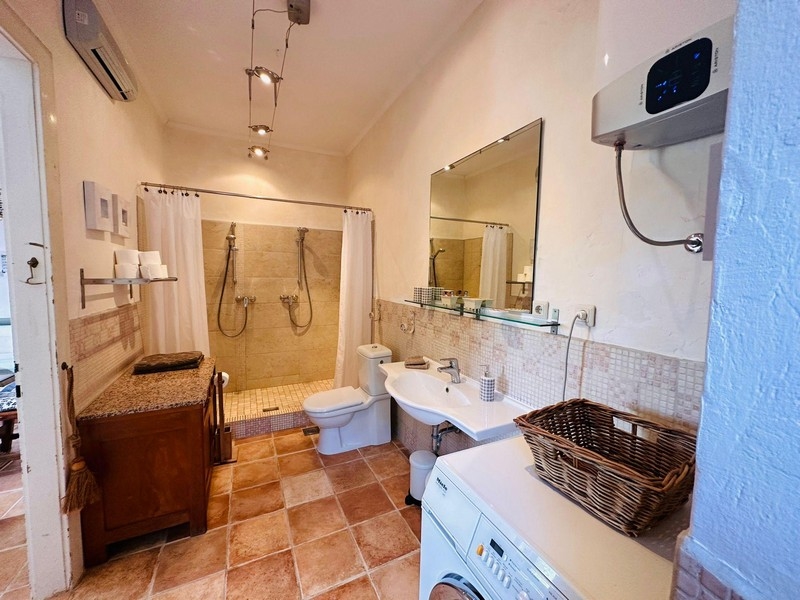 Grande salle de bains avec douche et lave-linge