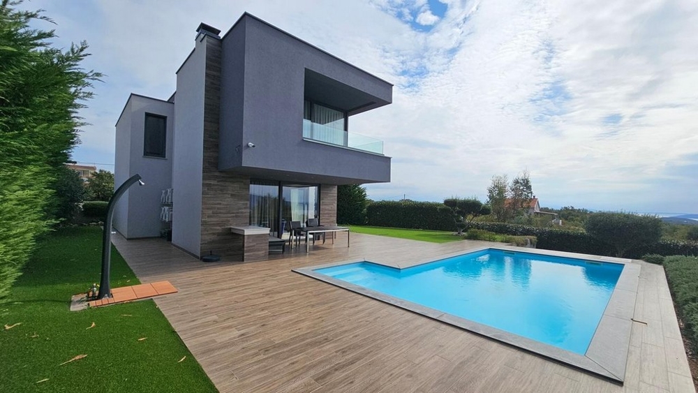 Villa moderne avec piscine et terrasse en bois dans le jardin