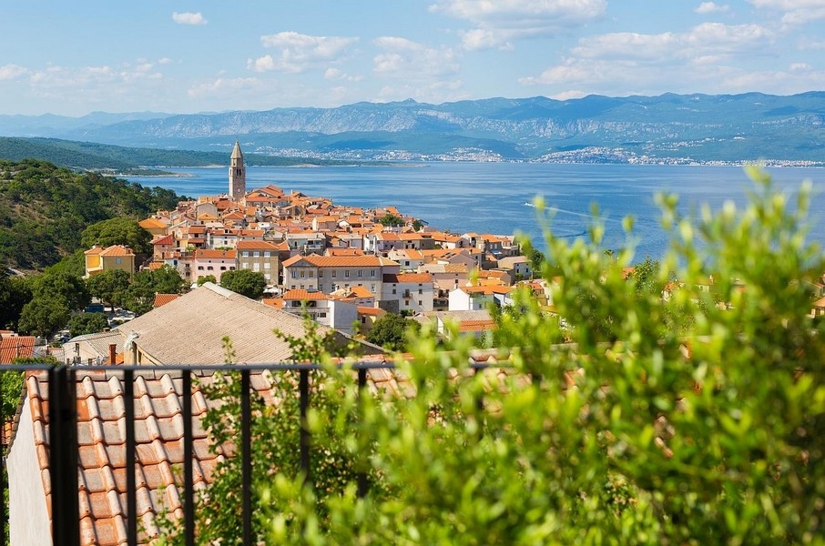 Vue sur le village avec clocher, la baie et les montagnes