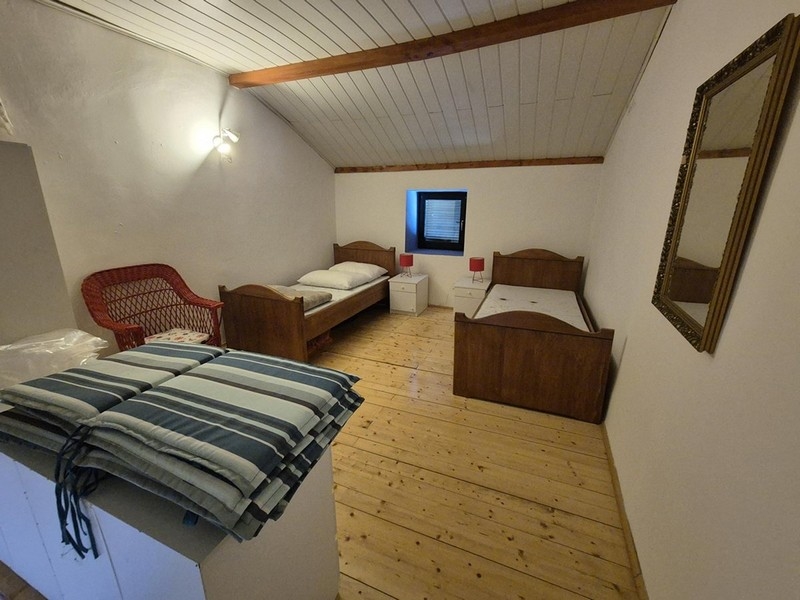 Chambre avec deux lits simples et aménagement sobre.