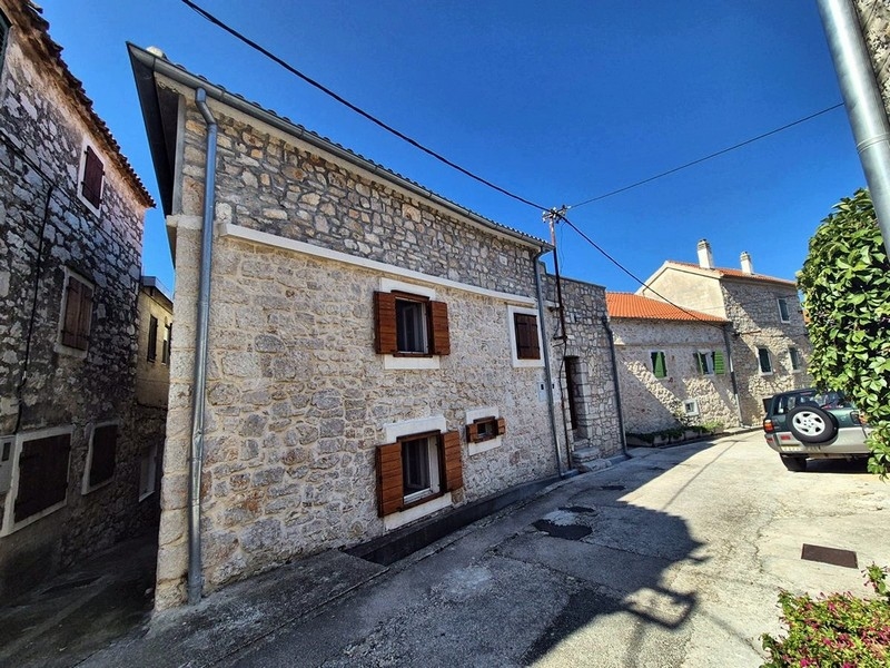 Maison en pierre avec volets en bois dans l'étroite rue du village