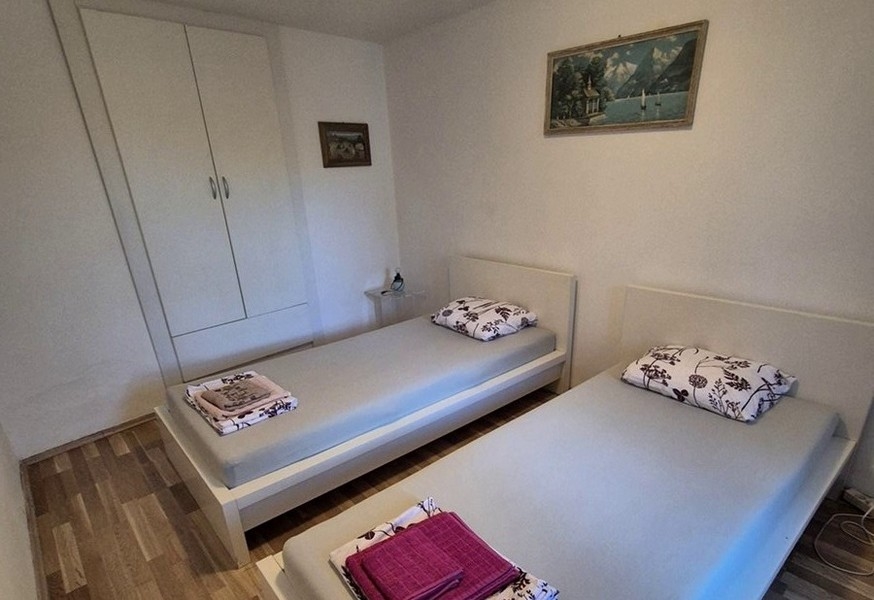 Chambre avec deux lits simples et meubles sobres.