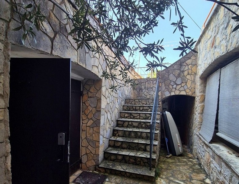 Escalier en pierre dans la cour intérieure menant aux étages supérieurs de la maison.