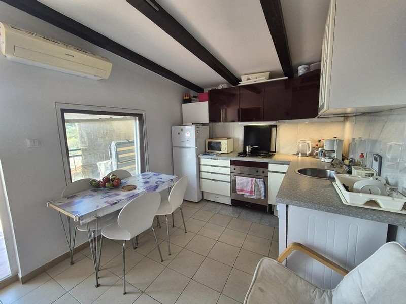 Cuisine moderne avec coin repas et climatisation au premier étage.