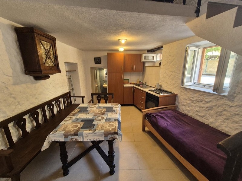 Coin repas et cuisine avec mobilier rustique au rez-de-chaussée de la maison.