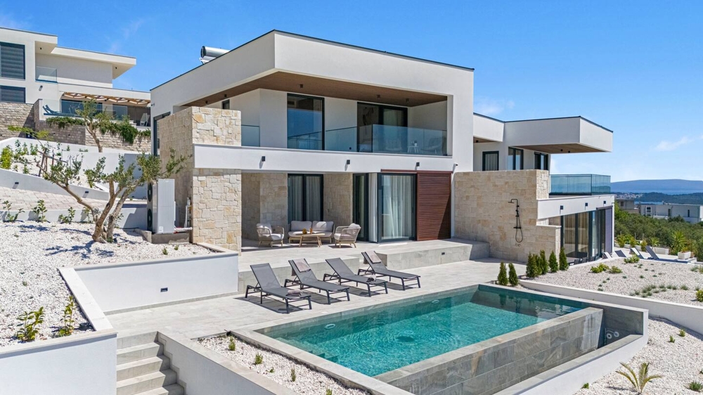 Villa avec bandes de pierre naturelle et piscine dans un jardin de gravier