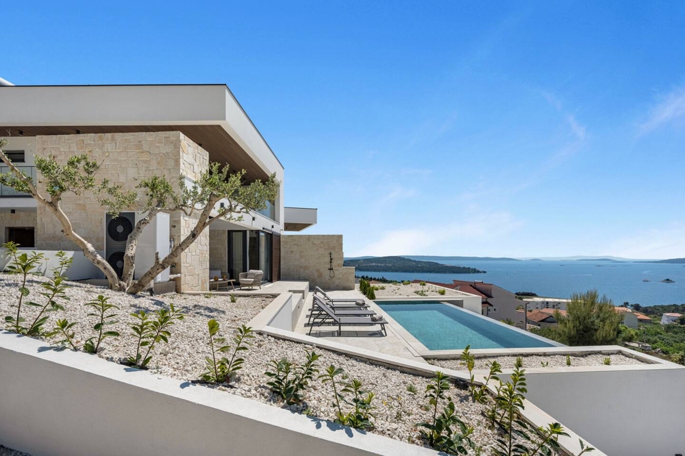 Olivier devant la villa avec piscine et vue sur la baie