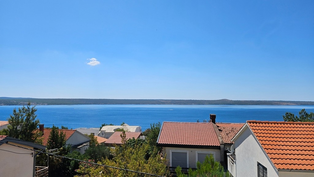 Toits de tuiles au premier plan et la baie derrière