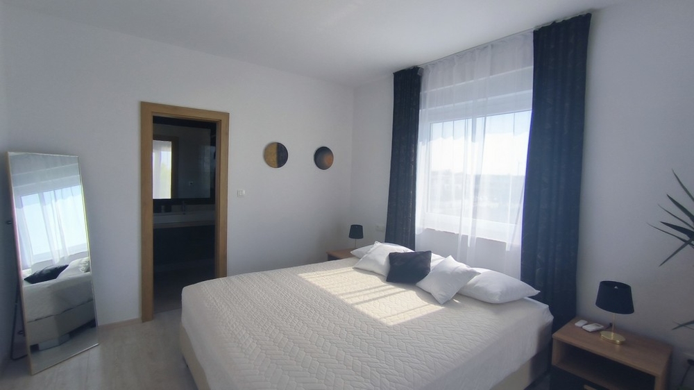 Deuxième chambre avec grand lit et salle de bains attenante.