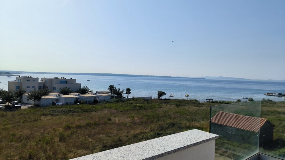 Vue mer depuis la terrasse avec maisons voisines et nature.