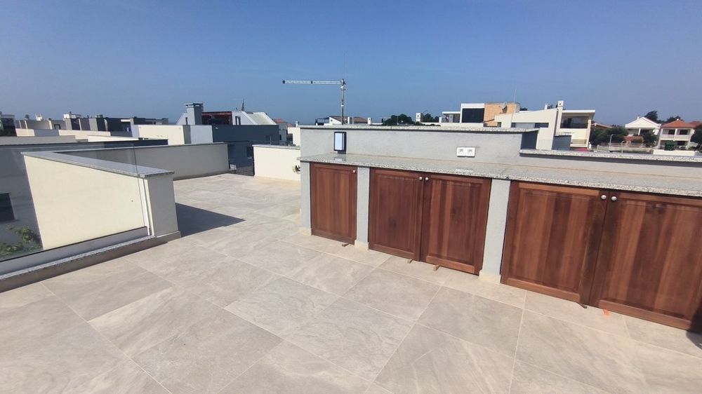Spacieux toit-terrasse avec meubles en bois encastrés.