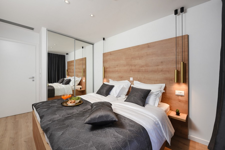 Chambre à l'aménagement moderne avec éléments en bois et armoire à portes coulissantes miroir.