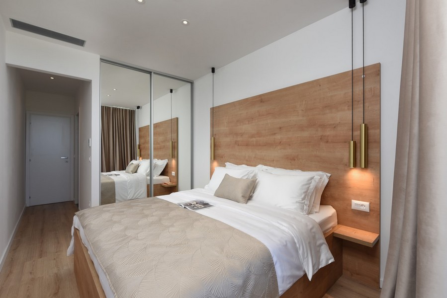Chambre agréable avec décoration en bois, armoire miroir et accès direct au balcon.