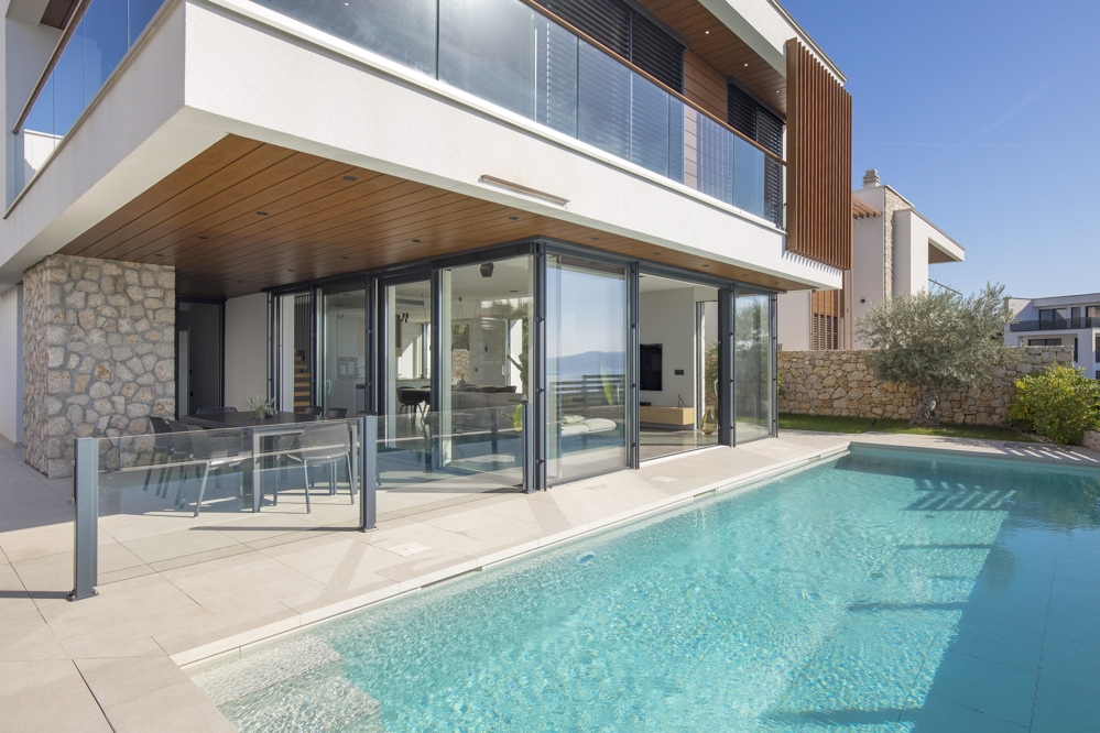Portes vitrées pliantes vers la piscine sous le plafond en bois