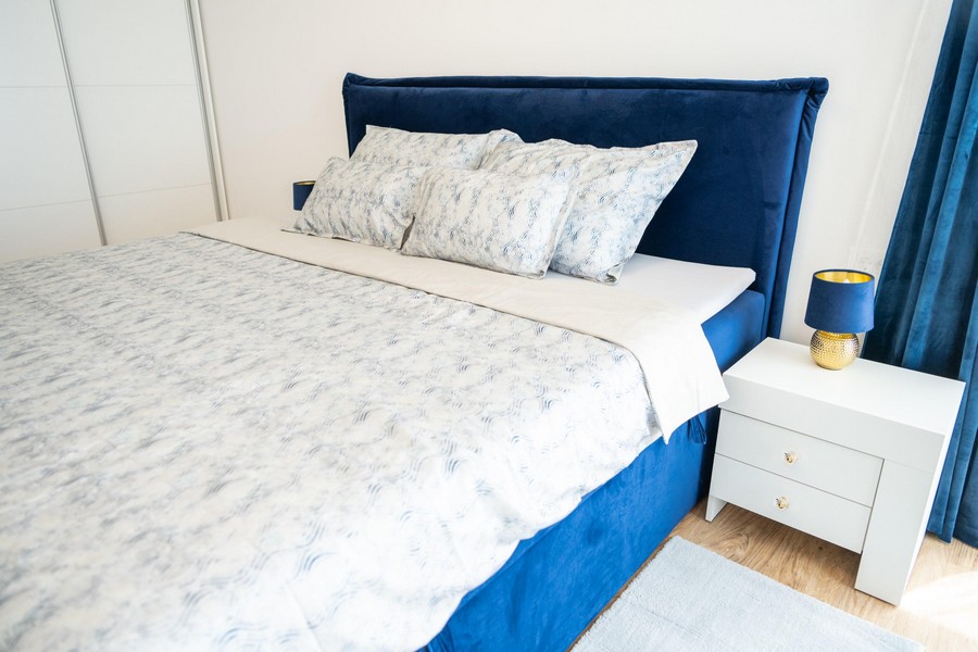 Chambre avec lit bleu et tables de chevet