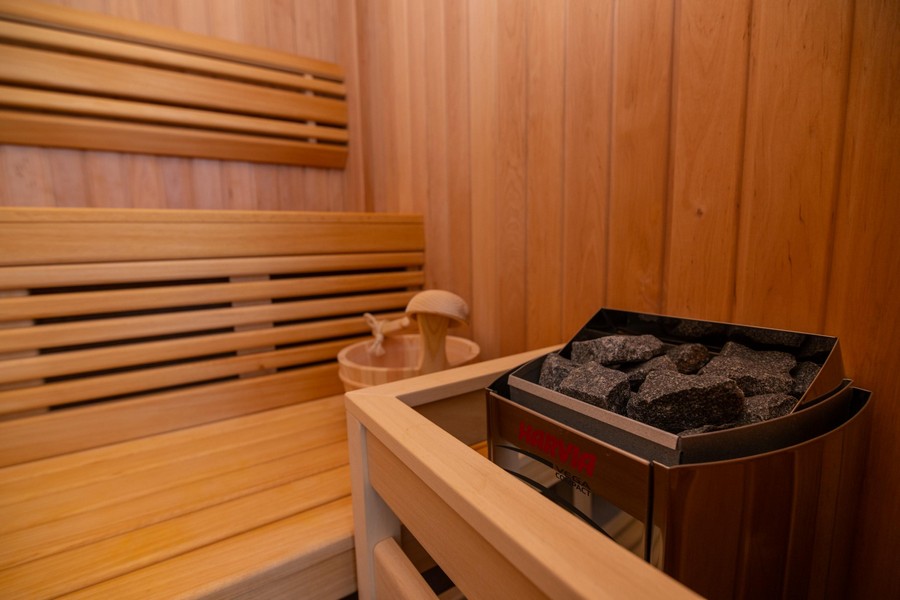 Sauna avec revêtement en bois et cheminée en pierre
