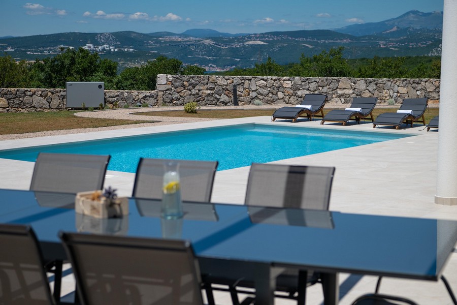 Espace extérieur avec piscine et transats, vue sur les montagnes