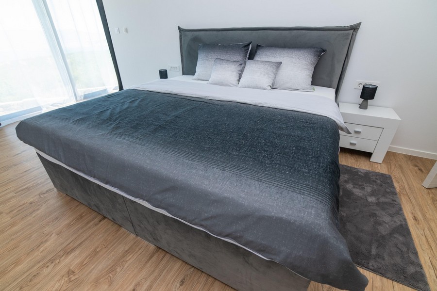Chambre avec lit gris et design moderne